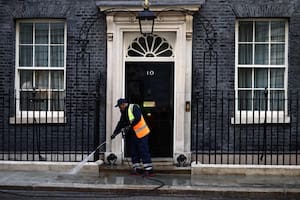 Un empleado limpia la entrada de Downing Street, la residencia del primer ministro