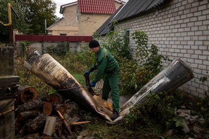 Un empleado municipal ata una cuerda alrededor de los restos de un misil en Kramatorsk