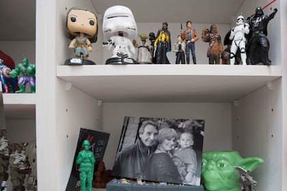 Un espacio de la biblioteca donde conviven las figuras de Star Wars con una foto de Fede junto a sus padres.