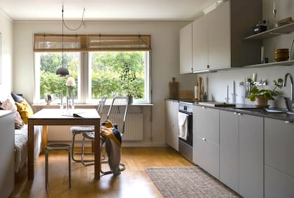 Un espacio que reúne cocina y comedor diario sobre el mismo piso de madera.