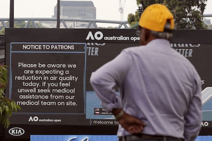 Un espectador lee las noticias relativas al clima: el efecto del humo en Melbourne domina la previa del Australian Open