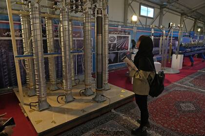Un estudiante observa las centrifugadoras de construcción nacional de Irán en una exposición de los logros nucleares del país, en Teherán, Irán, miércoles 8 de febrero de 2023. (AP Foto/Vahid Salemi)