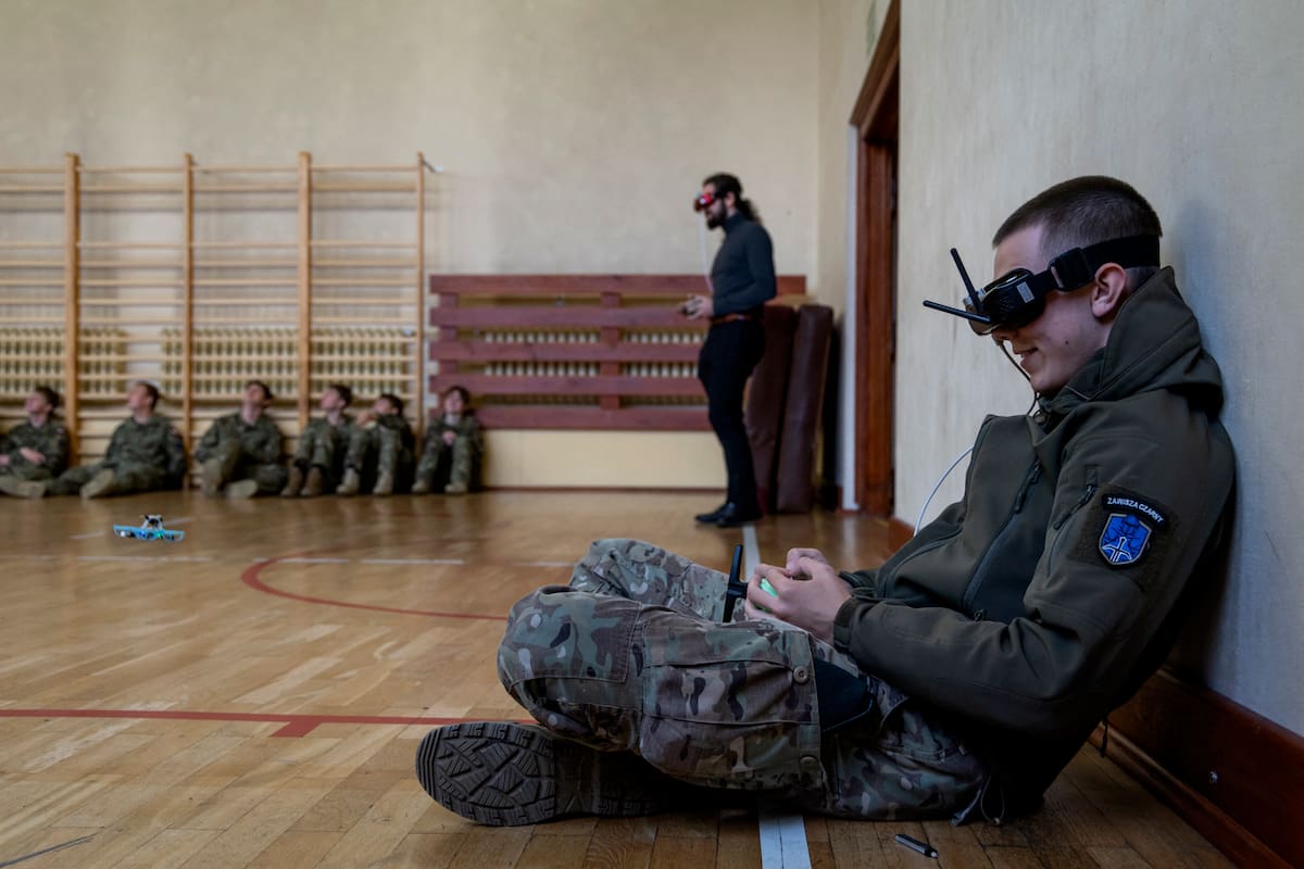 Un estudiante usa anteojos protectores mientras vuela un pequeño dron FPV en el gimnasio de la Escuela Militar de Legnica, en Legnica, al oeste de Polonia, el 8 de octubre de 2025. El primer curso de drones del país se lanzó en la ciudad de Legnica, al oeste de Polonia, pocos días antes de que Polonia sufriera en septiembre una incursión de unos 20 supuestos drones rusos. (Foto de Wojtek RADWANSKI / AFP)