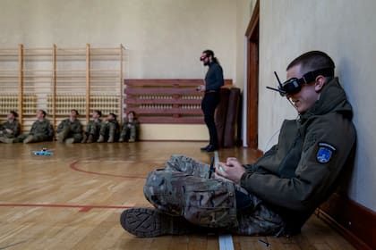 Un estudiante usa anteojos protectores mientras vuela un pequeño dron FPV en el gimnasio de la Escuela Militar de Legnica, en Legnica, al oeste de Polonia, el 8 de octubre de 2025. El primer curso de drones del país se lanzó en la ciudad de Legnica, al oeste de Polonia, pocos días antes de que Polonia sufriera en septiembre una incursión de unos 20 supuestos drones rusos. (Foto de Wojtek RADWANSKI / AFP)