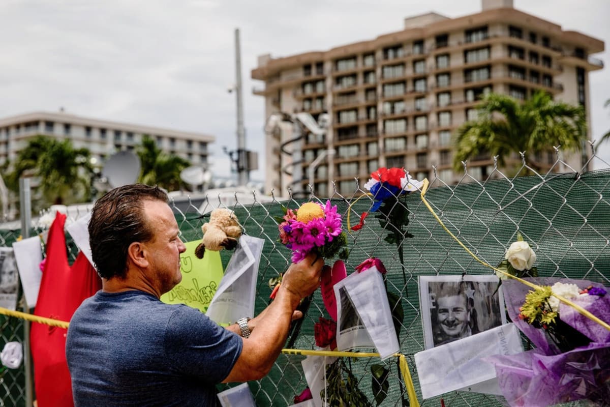 Un exresidente pone flores en un memorial improvisado a las víctimas del derrumbe de Surfside