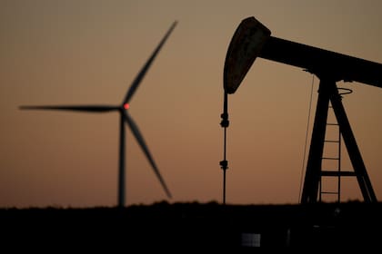 Un extractor de petróleo y un molino de energía eólica cerca de Hays, Kansas, el 30 de septiembre del 2024. (AP foto/Charlie Riedel)