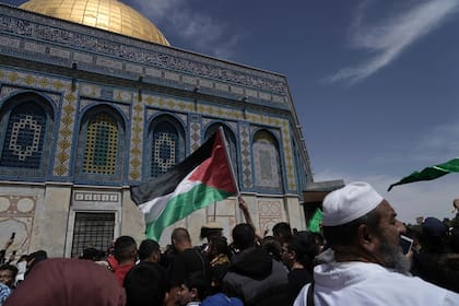 Un fiel ondea una bandera palestina tras la oración del viernes en el mes del ramadán, que es sagrado para los musulmanes, horas después de enfrentamientos entre la policía israelí y los manifestantes en el recinto de la mezquita de Al Aqsa, en la Ciudad Vieja de Jerusalén, el 22 de abril de 2022. (AP Foto/Mahmoud Illean)