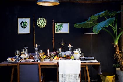 Un fondo oscuro para un encuentro luminoso en buena compañía. La elegancia del negro, los grises y el brillo de los espejos, las velas y la vajilla se suaviza con belleza flexible de las plantas.