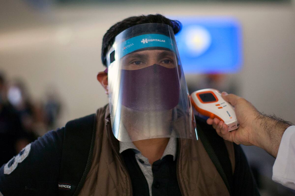 Un funcionario de salud verifica la temperatura corporal de un pasajero en el aeropuerto internacional de Monterrey, Nuevo León, México, el 18 de mayo de 2020 en medio de la pandemia de coronavirus