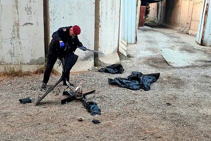 Un funcionario de seguridad inspecciona los restos de un dron en el aeropuerto de Bagdad, Irak, el 3 de enero de 2022. (Coalición Internacional vía AP)