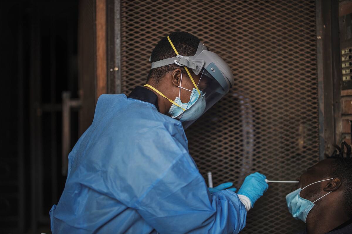 Un funcionario del Departamento de Salud de Gauteng recolecta muestras de un hombre durante una prueba de detección de coronavirus puerta a puerta en Yeoville, Johannesburgo, el 3 de abril de 2020