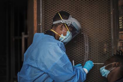 Un funcionario del Departamento de Salud de Gauteng recolecta muestras de un hombre durante una prueba de detección de coronavirus puerta a puerta en Yeoville, Johannesburgo, el 3 de abril de 2020