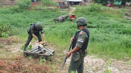 Un gendarme destruye unos tablones con una motosierra. Al poco tiempo, los paraguayos vuelven a reconstruirlo.