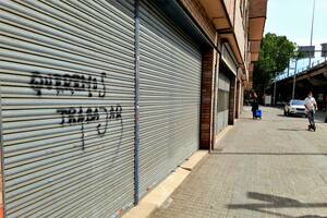 Un grafiti que dice "Queremos trabajar" escrito en la puerta de una tienda cerrada en Sant Adrià