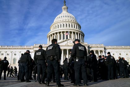 Un gran grupo de policías llega al Capitolio el jueves 6 de enero de 2022 en Washington. El presidente Joe Biden y los miembros del Congreso celebran solemnemente el primer aniversario de la insurrección del 6 de enero en el Capitolio de los Estados Unidos.