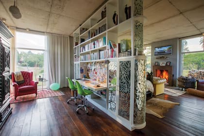 Un gran mueble, revestido con un mosaico de espejos rotos, divide el escritorio del dormitorio de los dueños de casa. Al lado de un sillón, donde Javier suele leer, se ve una lámpara Guzzini original.