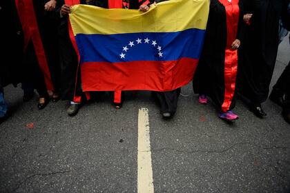 Un grupo de abogados que llevan una bandera nacional venezolana protestan frente al edificio de la Corte Suprema de Justicia de Venezuela contra la ausencia del estado de derecho en el país