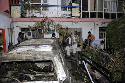 Un grupo de afganos dentro de una casa después del ataque con aviones no tripulados estadounidenses en Kabul, Afganistán, ayer