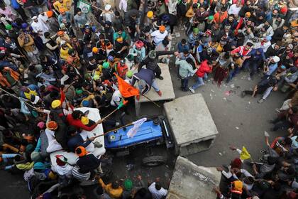 Un grupo de agricultores intenta abriese paso con sus tractores entre las barricadas que protegen el centro de Nueva Delhi.