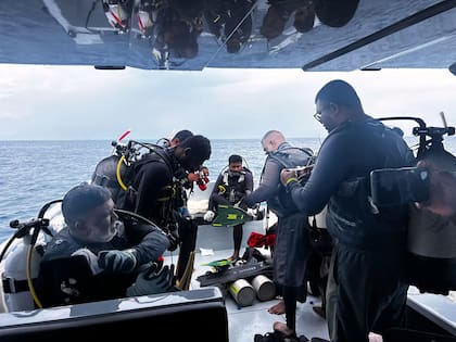 Un grupo de buzos preparándose para buscar a cuatro italianos desaparecidos cerca de la isla Alimathaa, Maldivas