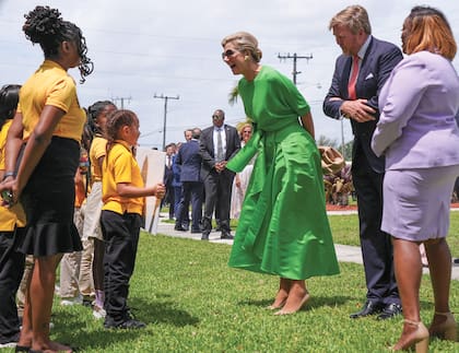 Un grupo de chicos agitan banderas neerlandesas
durante la visita de Sus Majestades a una escuela pública de Miami en donde artistas de los Países
Bajos y del Caribe, que forman parte del Reino,
pintaron murales