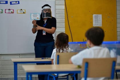 Un grupo de chicos usa tapabocas como medida preventiva contra la propagación del coronavirus, mientras asisten a una clase en Yumbo, departamento del Valle del Cauca, Colombia, el 29 de enero pasado