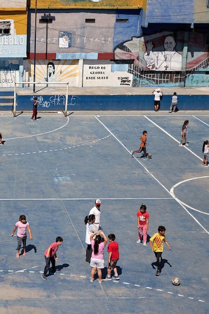 Un grupo de chicos y chicas de jardín de infantes hace Educación Física en el patio del colegio