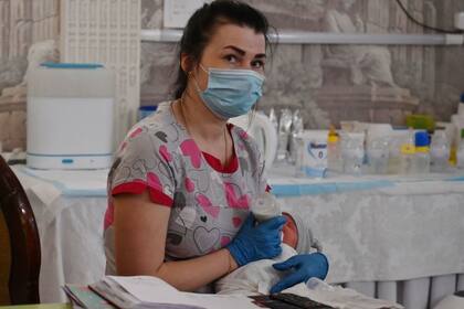 Un grupo de enfermeras cuida a los recién nacidos hasta que los padres puedan entrar al país.