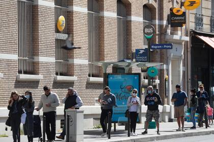 Un grupo de franceses hacen fila frente a una sucursal de correo en París, en el 35° día de confinamiento