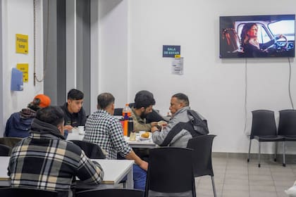 Un grupo de hombres cena en uno de los dispositivos dispuestos por la Ciudad en Constitución