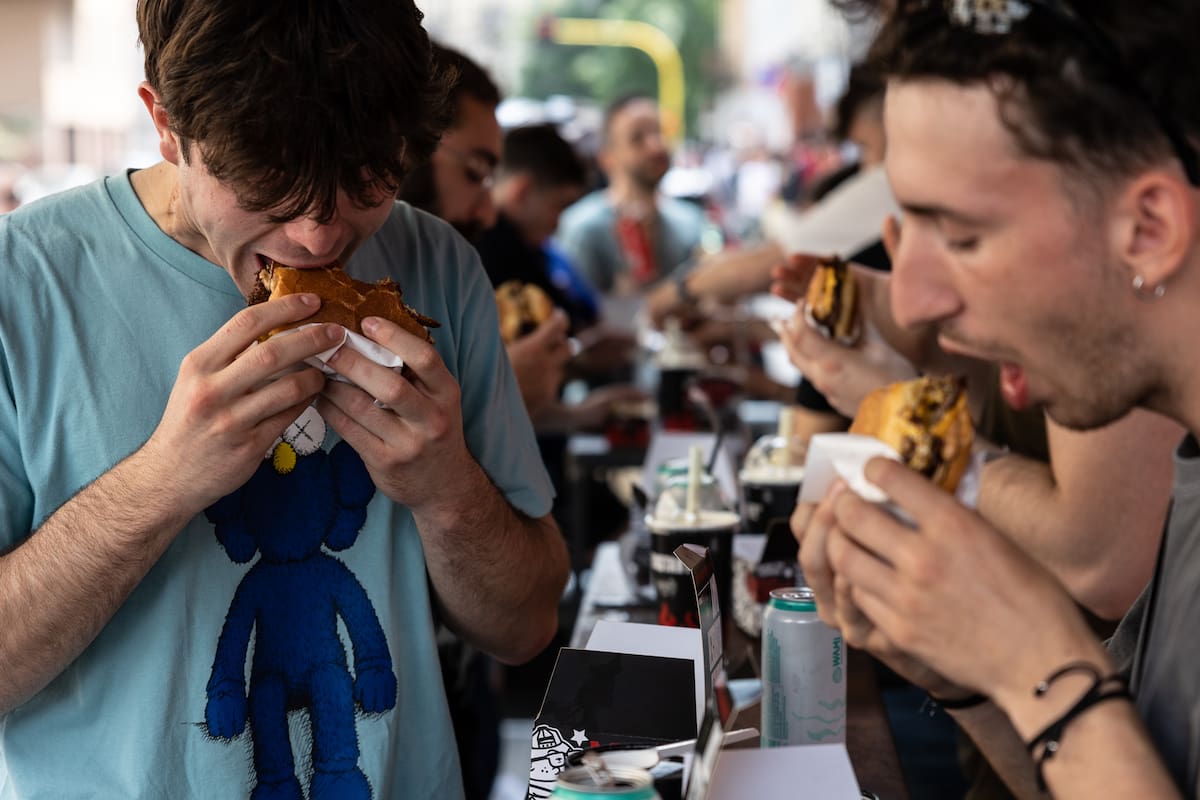 Un grupo de jóvenes come hamburguesas en un restaurante de Milán en 2023.