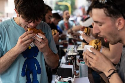 Un grupo de jóvenes come hamburguesas en un restaurante de Milán en 2023.