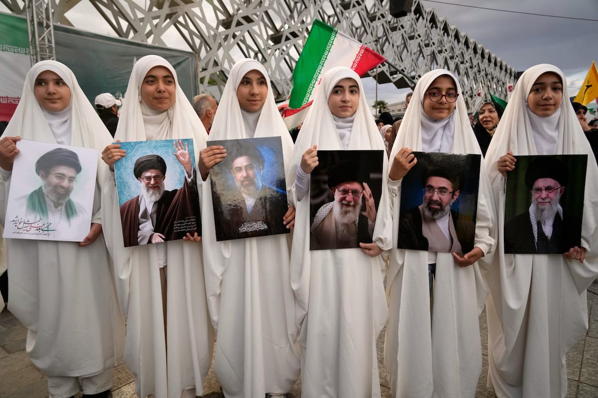 Un grupo de jóvenes sostiene retratos del líder supremo de Irán, el ayatollah Mojtaba Khamenei, y de su difunto padre, el también exlíder supremo, Ali Khamenei