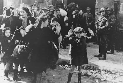 Un grupo de judíos, entre ellos un niño pequeño, es escoltado fuera del gueto de Varsovia por soldados alemanes el 19 de abril de 1943 (Foto: archivo AP)