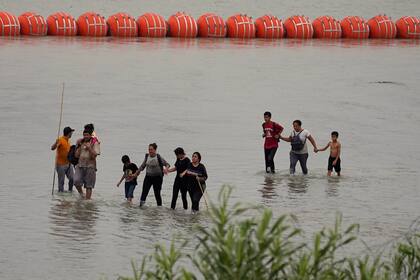 Un grupo de migrantes cruzan el Río Grande desde México en Eagle Pass, Texas, en julio de 2023