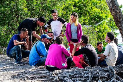 Un grupo de migrantes cubanos se reúne cerca de un camino en la isla Duck Key el lunes 2 de enero de 2023, en los cayos de Florida. (Pedro Portal/Miami Herald vía AP)