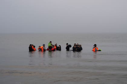 Un grupo de migrantes kurdos de Irán e Irak que fallaron en su intento de llegar a Reino Unido en barco luego de ser descubiertos por la policía se rehúsa a regresar a la costa de la playa de Ambleteuse, en el norte de Francia, el domingo 19 de mayo de 2024. (AP Foto/Bernat Armangue)