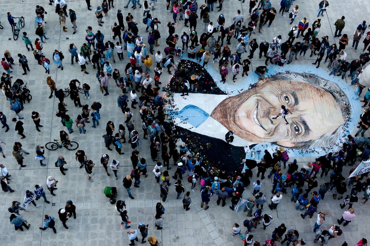 Un grupo de militantes alrededor del mural de Néstor Kirchner, en Plaza de Mayo