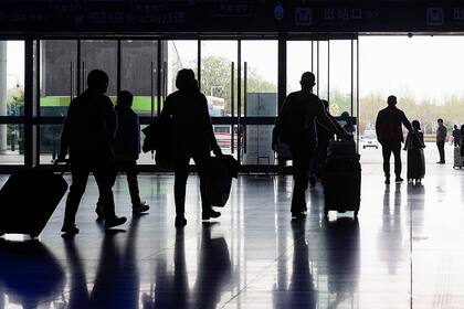 Un grupo de pasajeros llega, ayer, a la estación de trenes de Wuhan, que lentamente recupera la normalidad