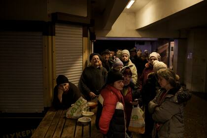 Un grupo de personas espera en fila para recibir comida en una estación de metro utilizada como refugio antibombas, mientras continúan los ataques rusos sobre Járkiv, Ucrania, el 25 de marzo de 2022. (AP Foto/Felipe Dana)