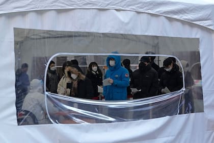 Un grupo de personas espera para someterse a las pruebas del coronavirus en un centro de salud pública en Seúl, Corea del Sur