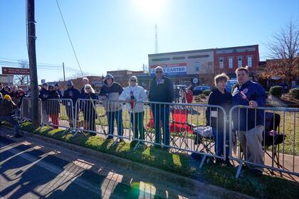 Un grupo de personas espera para ver pasar el féretro del expresidente estadounidense Jimmy Carter en Plains, Georgia, (AP foto/Alex Brandon, Pool)