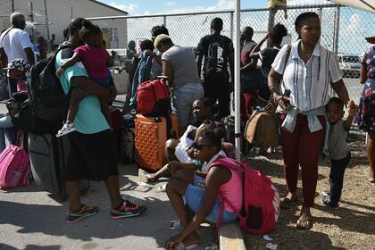 Un grupo de personas espera que verifiquen sus documentos para poder volar a Estados Unidos en el aeropuerto de Freeport en la isla de Gran Bahama el 10 de septiembre de 2019