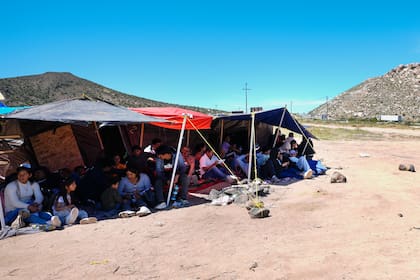 Un grupo de personas esperan a ser procesadas después de cruzar la frontera entre México y Estados Unidos