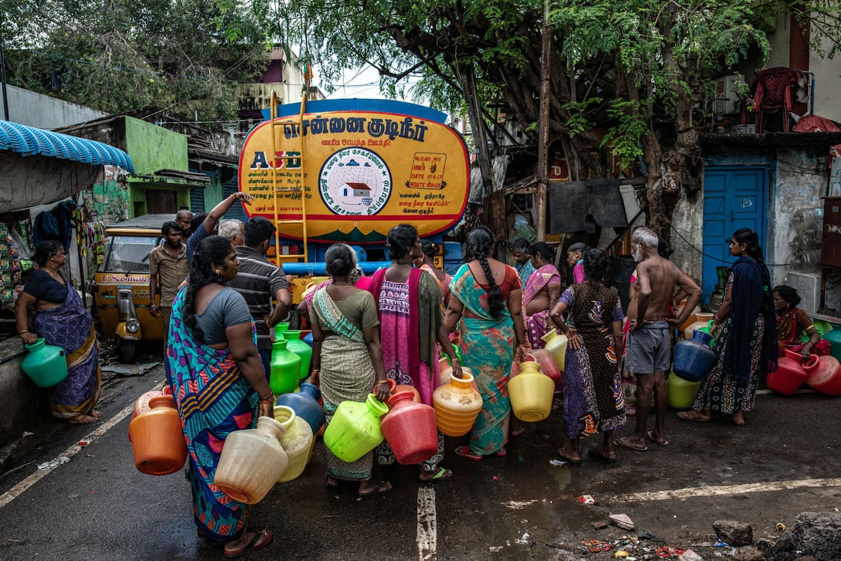 Un grupo de personas hace fila para obtener agua de una cisterna en la ciudad de Chennai.Credit...