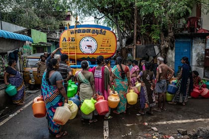 Un grupo de personas hace fila para obtener agua de una cisterna en la ciudad de Chennai.Credit...
