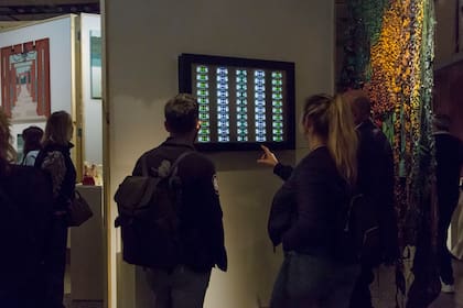 Un grupo de personas mira "VU", de Luciano Colman exhibido en la galería Sasha D