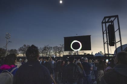 Un grupo de personas miran el eclipse solar en el Parc Jean Drapeau de Montreal (Ryan Remiorz/The Canadian Press via AP)