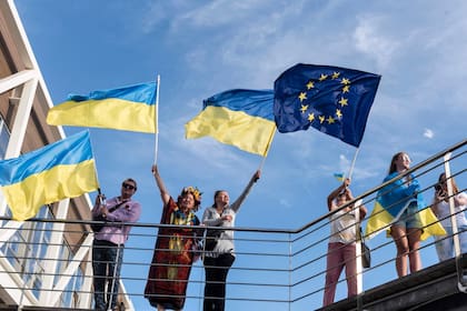 Un grupo de personas ondea banderas europeas y ucranianas durante una manifestación en solidaridad con Ucrania en la ciudad portuaria de Limassol, al sur de Chipre, mientras los europeos conmemoran la victoria de los Aliados contra la Alemania nazi y el fin de la Segunda Guerra Mundial en Europa (Día de la Victoria), el 8 de mayo de 2022.