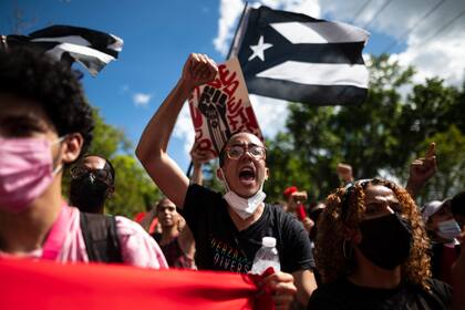 Un grupo de personas protestan contra el Plan de Ajuste de Deuda en el exterior de la Corte Federal donde lo estudia la juez Laura Taylor Swain, en San Juan, Puerto Rico, el 8 de noviembre de 2021. (AP Foto/Carlos Giusti)